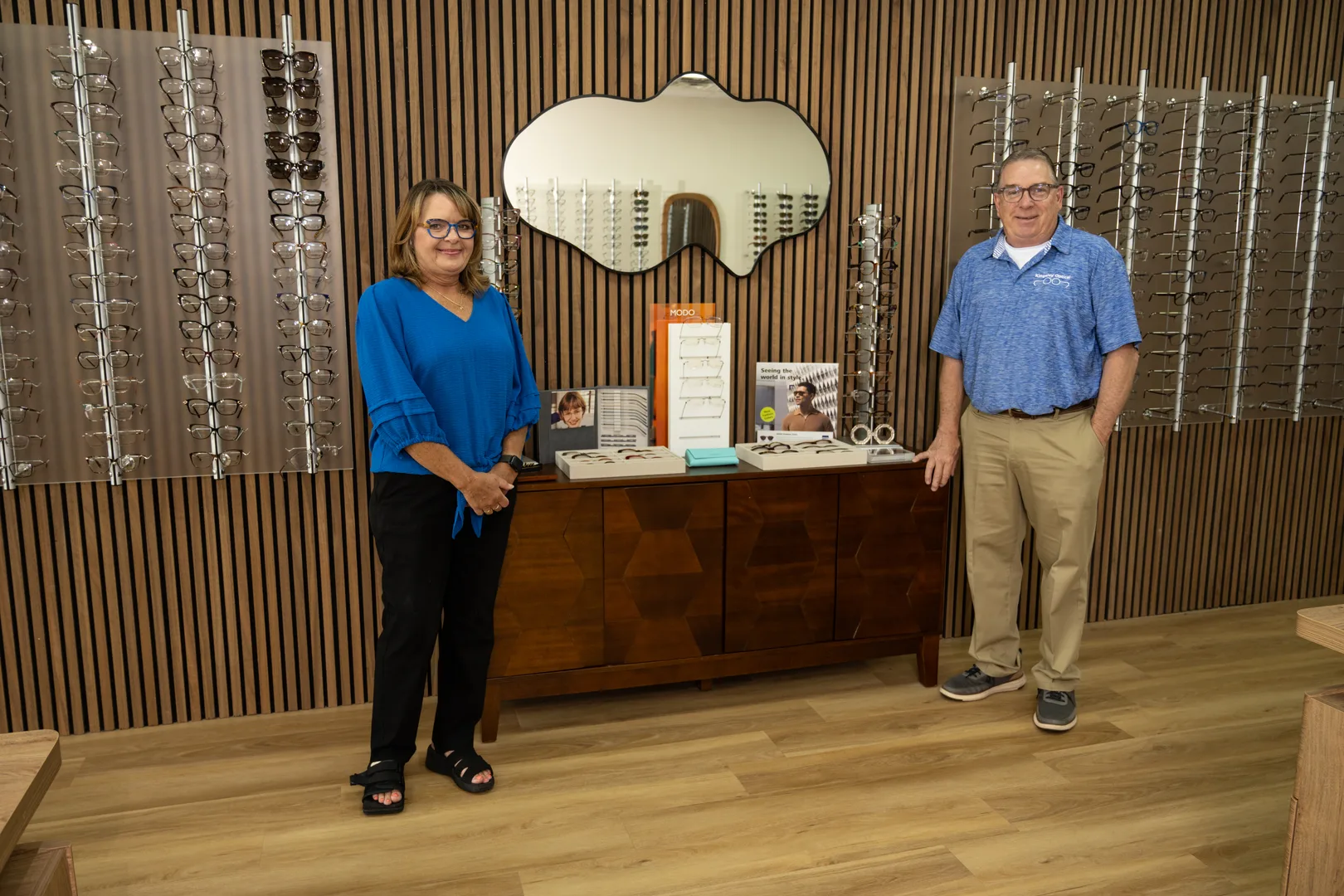 Two Kingsley Optical staff members standing in the showroom beside frame displays