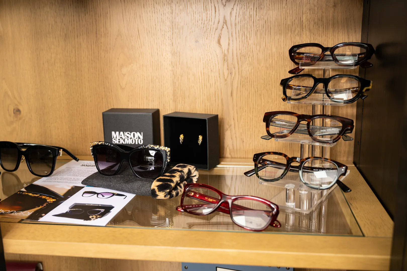 Maison Sekimoto jeweled sunglasses and tortoiseshell frames on a display shelf