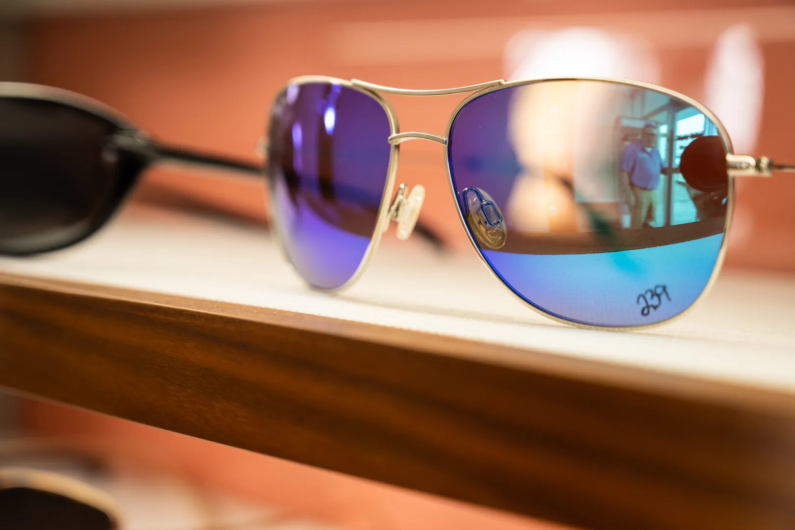 Blue mirrored aviator sunglasses on a showroom shelf